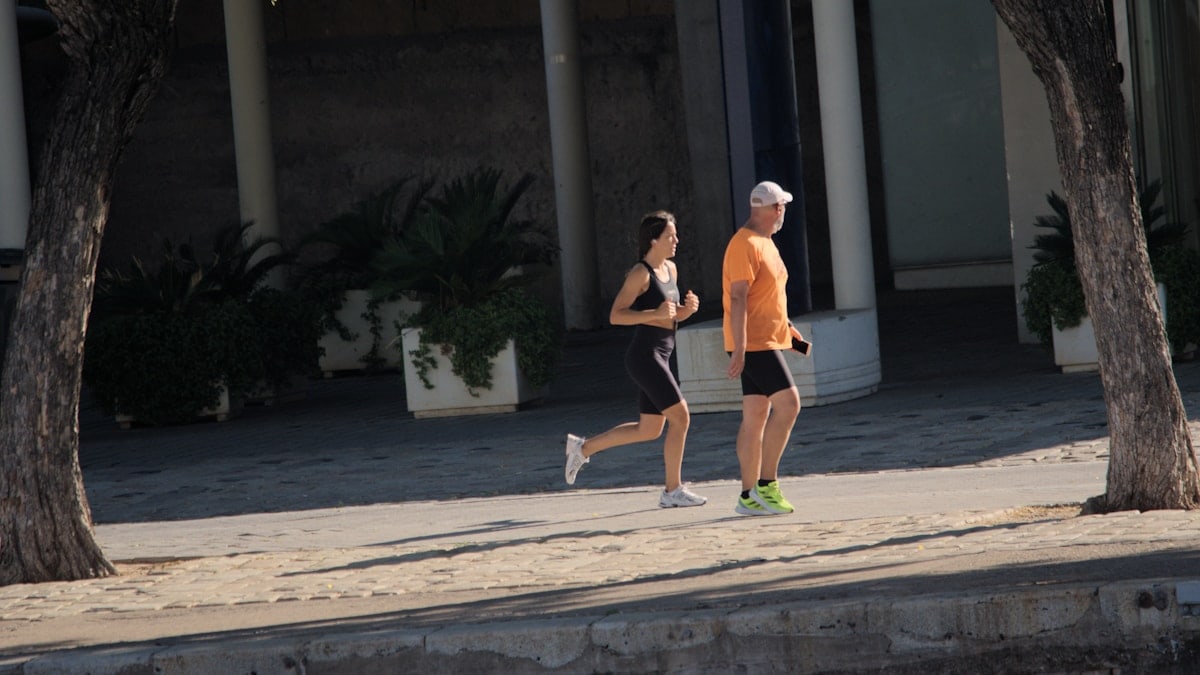 A man and a woman running down a street